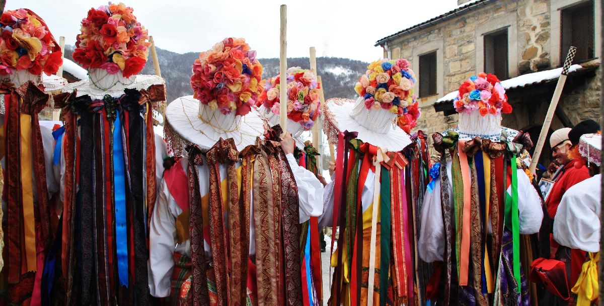 hombres vestidos con ropas de colores y sombreros adornados con flores y bisutería